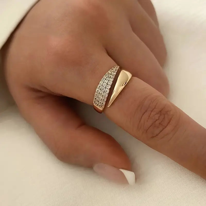 Elegantiškas auksinis žiedas su blizgančia akmeniu